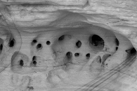 Patterns and textures of a rock wall with holes, black and white Stock Photos