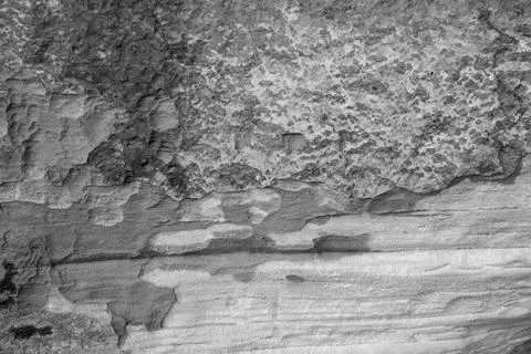 Patterns and textures of a rock wall with holes, black and white Stock Photos