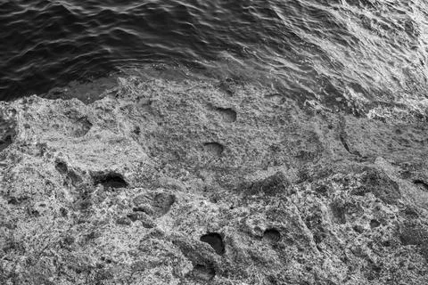 Patterns and textures of a rock wall with holes, black and white Stock Photos