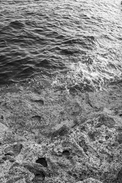 Patterns and textures of a rock wall with holes, black and white Stock Photos