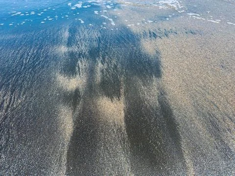 Patterns on the beach emerge from the water running over sand during low ti.. Photos