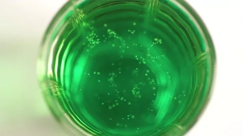 The patterns of bubbles in a green soda Stock Footage 134908378