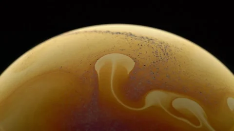 Patterns of golden color on the surface of the soap bubble. Close-up. Stock Footage 145124502