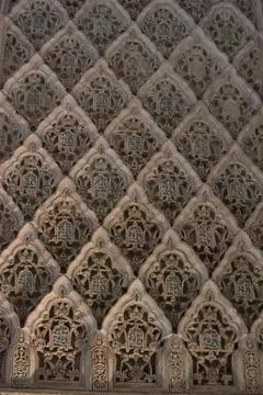 Patterns of plaster cover the surface in rows. Arches repeat from top to bott Stock Photos