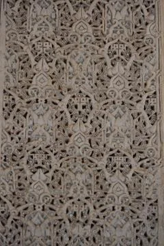 Patterns of plaster cover the surface in rows. Arches repeat from top to bott Stock Photos