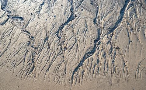Patterns on sandy beach after low tide on the ocean.abstract sand nature back Stock Photos