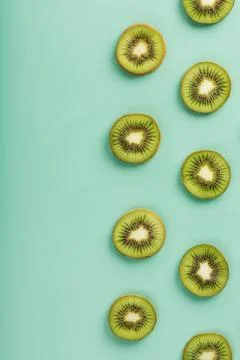 The patterns of the slices of kiwi fruit on green background as a continuous  Fotos de archivo
