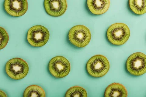 The patterns of the slices of kiwi fruit on green background as a continuous  Fotos de archivo