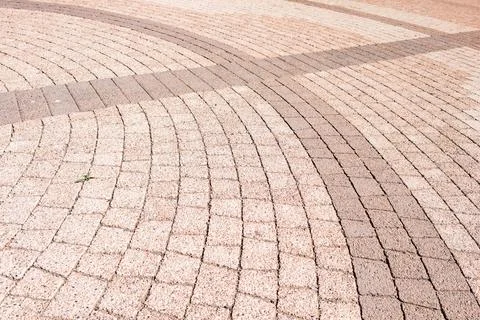 Patterns of stone paving in a public space during daylight showcase curved lines Stock Photos