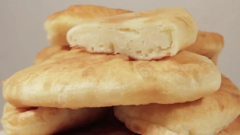 Patties with stuffing of potatoes rotating on light background Stock Footage 70070364