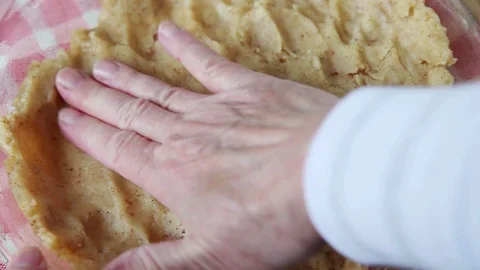 Patting a cookie crust in a pie pan Stock Footage 99412450