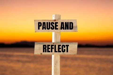 Pause and reflect message written on wooden sign with blurry lake background. Stock Photos