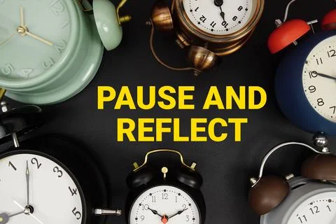 Pause and Reflect text with alarm clock on black background Stock Photos