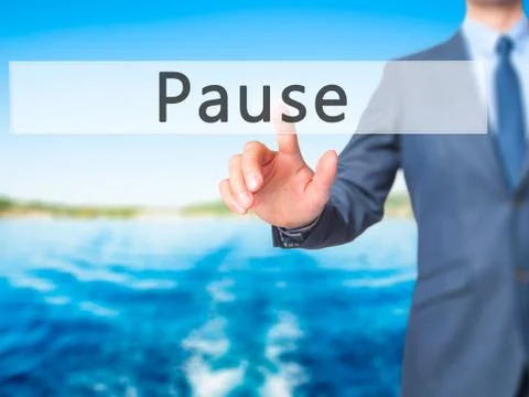 Pause - Businessman hand pressing button on touch screen interface. Stock Photos