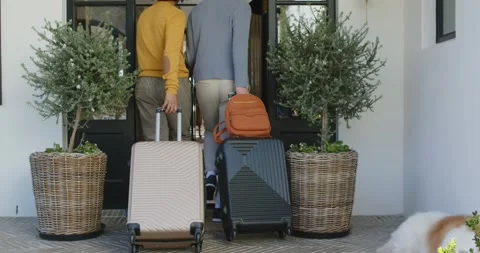 Pause ending as two adults are pushing open front door walking inside pulling Видео 344656340