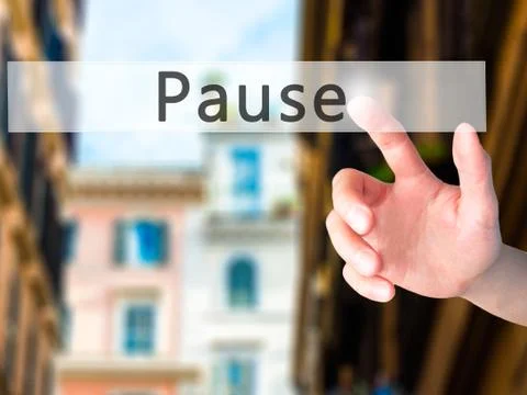 Pause - Hand pressing a button on blurred background concept on visual screen Stock Photos