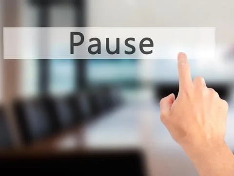 Pause - Hand pressing a button on blurred background concept on visual screen Stock Photos