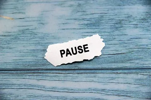 Pause wording  or text on small piece of hard white plastic with blue backg.. Stock Photos