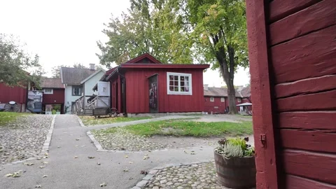 Paved Courtyard Path beside Red Wooden Buildings in Sweden Vidéo 347682797