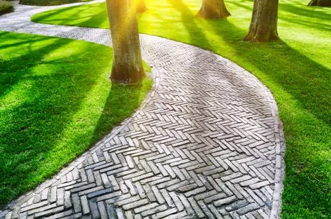 Paved footpath in spring park Stock Photos