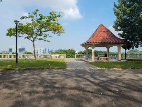 Paved path leads to a gazebo with a red-tiled roof Stock Photos