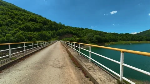 Paved path runs over calm turquoise water. Zavoj Lake, Serbia Stock Footage 337492667
