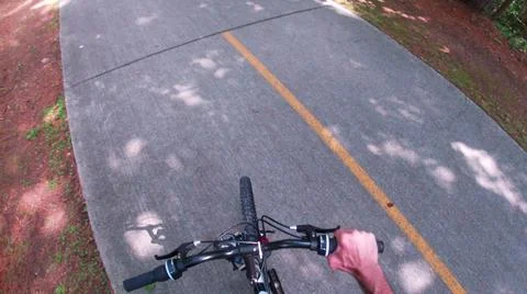 A paved path at the Silver Comet Trail hand on a bike handle bar grip Photos