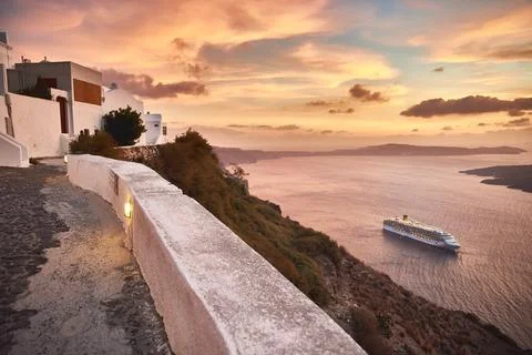 Paved pedestrian path along a cliffside wall overlooking a cruise ship and th Stock Photos