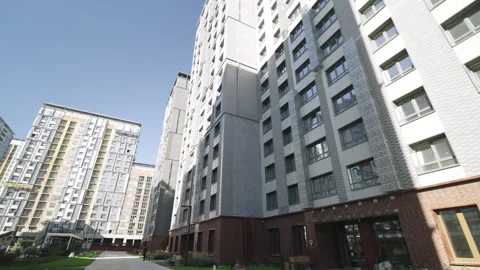 Paved road between apartment buildings on summer day Видео 330931846