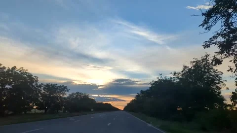 Paved road stretching towards a scenic sunset sky Stock Footage 341280191