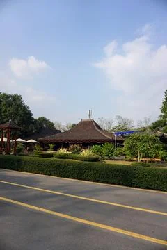 Paved road surrounded by lush trees near the exit of Prambanan Temple cultural Stock Photos