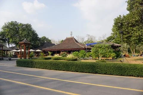 Paved road surrounded by lush trees near the exit of Prambanan Temple cultural Stock Photos