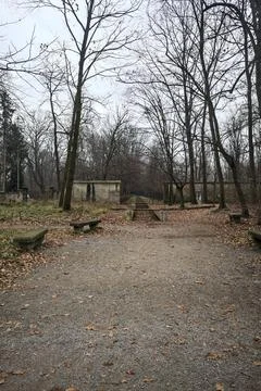 Paved square next to a wall and a trench with stone benches in a park in autu Stock Photos