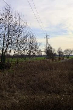 Paved trail bordered by a railing and a stream of water between fields and .. Stock Photos