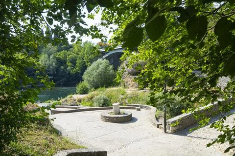 A paved walkway with a circular stone structure and a stump in Podgorica, M.. Stock Photos