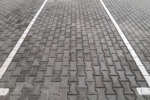 Pavement blocks form a grid pattern in the parking lot with white lines mar.. Foto stock