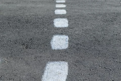 On the pavement marking. Rough intermittent white line. Stock-Fotos