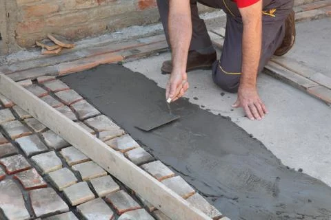 Pavement or terrace making, worker spreading mortar Fotos Stock