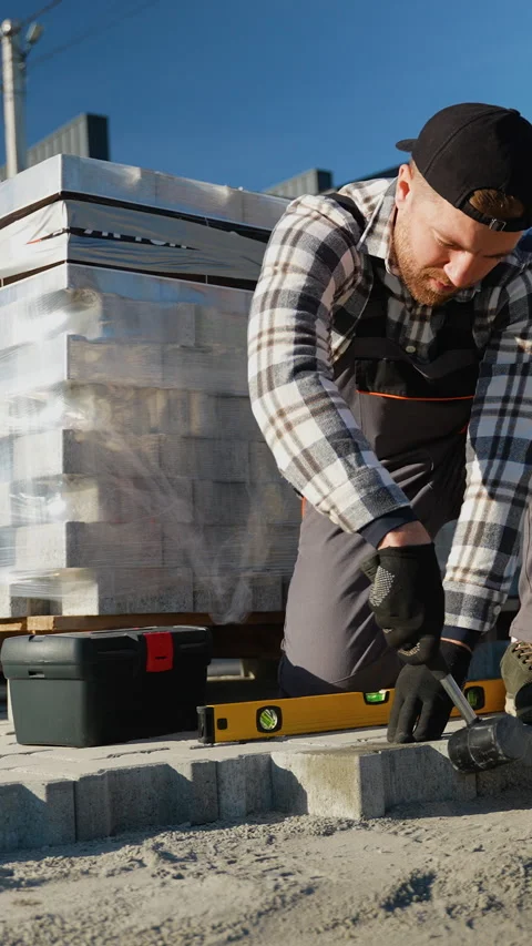 Paver Installer Using Hammer to Secure Paving Stones Stock Footage 297787141