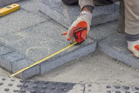 Paver measuring irregular space for laying concrete brick 스톡 사진