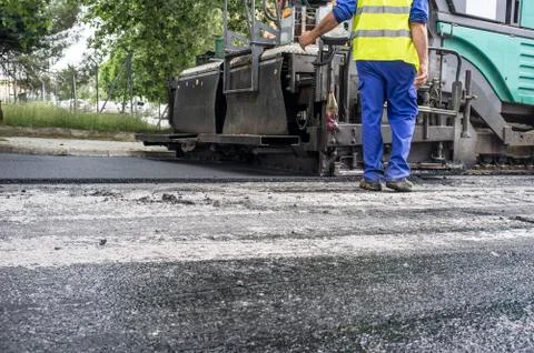 Paving applicator machine or paver with worker Stock Photos
