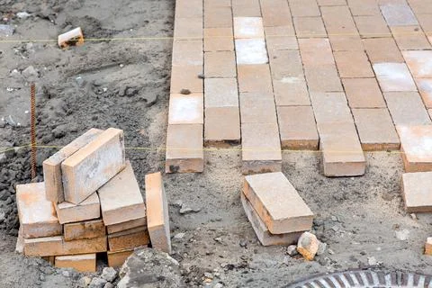 Paving of a new sidewalk from rectangular stone tiles. 스톡 사진