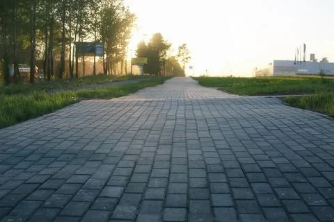 Paving stone path goes away the prospect in sunset Stock Photos