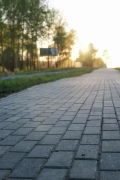 Paving stone path goes away the prospect in sunset Stock Photos