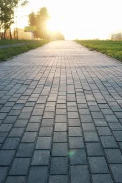 Paving stone path goes away the prospect in sunset Stock Photos