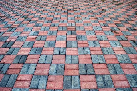 Paving stone surface featuring a pattern of red and gray bricks. The interl.. Stock Photos