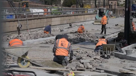 Paving stone workers during the tramway route construction. 库存影片 87735124