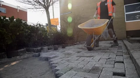 Paviour unloading bricks from wheelbarrow Video stock 62197970