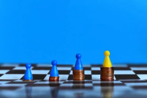 Pawns standing on piles of different sizes of coins. Economic growth concept. Stock Photos