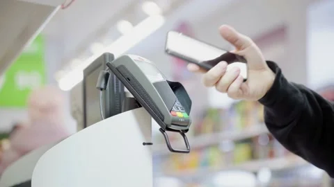 Pay for goods through the terminal in a contactless way in a supermarket. Using Stock Footage 149671606